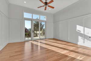 Unfurnished room featuring a decorative wall, light wood finished floors, ornamental molding, a ceiling fan, and recessed lighting