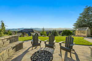 View of patio with a mountain view, an exterior structure, an outdoor fire pit, and an outbuilding