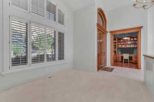 Unfurnished room with built in study area and a towering ceiling
