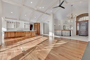 Reception featuring a chandelier, high vaulted ceiling, ceiling fan, and beam ceiling