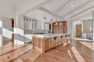 Kitchen with white cabinets, glass insert cabinets, light wood-type flooring, and recessed lighting