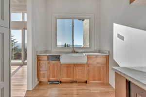 Kitchen featuring light brown cabinets, light wood finished floors, and light stone counters
