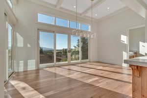 Unfurnished living room with light wood-style flooring, beamed ceiling, a high ceiling, and recessed lighting