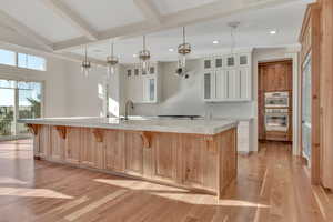 Kitchen featuring beamed ceiling, a kitchen breakfast bar, light brown cabinets, light wood-style floors, and recessed lighting