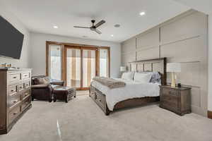 Bedroom with light colored carpet, a ceiling fan, a decorative wall, and recessed lighting