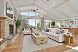 Virtual Staged - Living area featuring a fireplace, light wood-style floors, beamed ceiling, high vaulted ceiling, and plenty of natural light