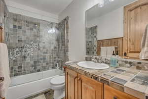 Full bath featuring bath / shower combo with glass door and vanity