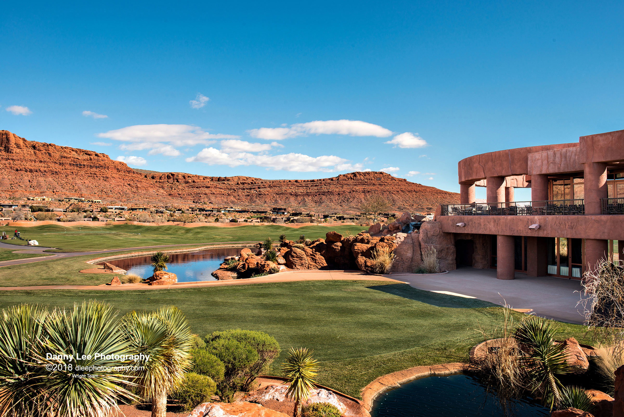 View of green lawn with view of golf course, a water and mountain view, a patio, and a balcony