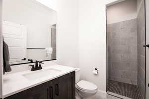 Full bath featuring vanity and tiled shower