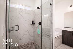 Bathroom with a stall shower, a garden tub, and vanity
