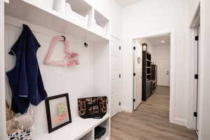 Mudroom featuring light wood-style floors and baseboards
