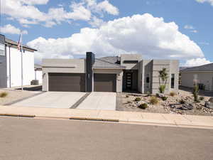 Contemporary house with a garage, stucco siding, and driveway
