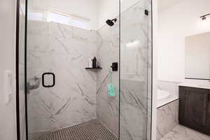 Bathroom with a marble finish shower and vanity