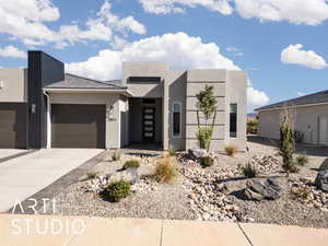 Contemporary home featuring concrete driveway, stucco siding, and a garage