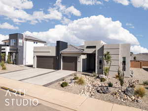 Contemporary house with stucco siding, driveway, and an attached garage