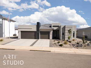 Contemporary home with an attached garage, stucco siding, and driveway