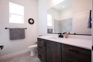 Bathroom with vanity, light tile patterned floors, and recessed lighting