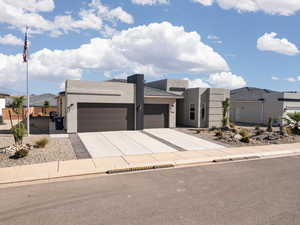 View of front of property with stucco siding, a garage, and concrete driveway