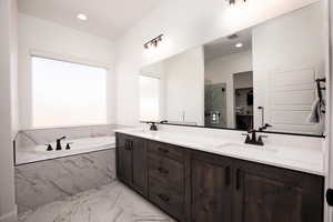 Bathroom with double vanity, light marble finish flooring, a garden tub, a marble finish shower, and recessed lighting