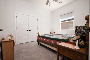 Carpeted bedroom featuring a closet and a ceiling fan