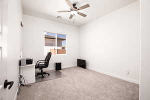 Office area with light carpet and ceiling fan