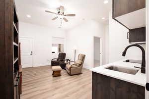 Sitting room featuring light wood-style floors, a ceiling fan, and recessed lighting