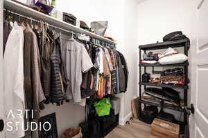 Walk in closet with light wood-type flooring