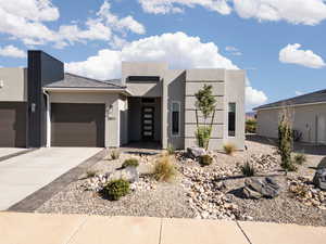 Modern home with driveway, stucco siding, and an attached garage