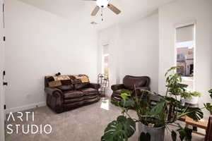 Living area featuring carpet flooring and ceiling fan