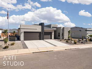 View of front of property with stucco siding, an attached garage, and concrete driveway
