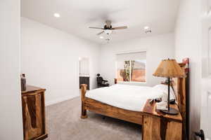 Carpeted bedroom with a ceiling fan, recessed lighting, and connected bathroom