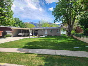 Single story home with a mountain view, brick siding, driveway, and an attached carport