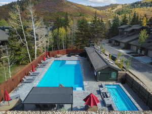 Community pool featuring a patio area, a fenced backyard, and a mountain view