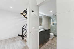 Full bathroom featuring light wood finished floors, walk in shower, and vanity