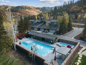 View of subject property featuring a pool and a forest