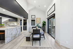 Dining space featuring high vaulted ceiling, recessed lighting, light wood-type flooring, and wine cooler