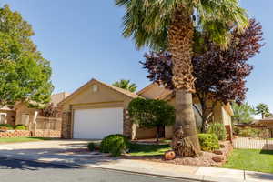 View of front of home with stucco siding, concrete driveway, a garage, and stone siding