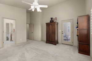 Unfurnished bedroom with light colored carpet, a towering ceiling, ceiling fan, access to exterior, and connected bathroom