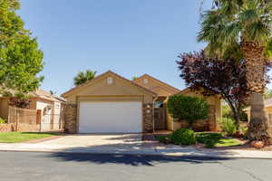 View of front of home with stucco siding, driveway, and an attached garage