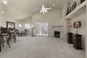 Living room featuring light carpet, a fireplace, high vaulted ceiling, recessed lighting, and ceiling fan