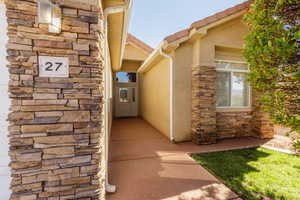 View of exterior entry featuring stone siding and stucco siding