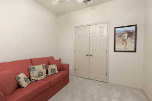 Sitting room featuring carpet and a ceiling fan