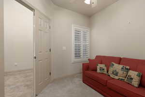Sitting room with carpet floors and a ceiling fan