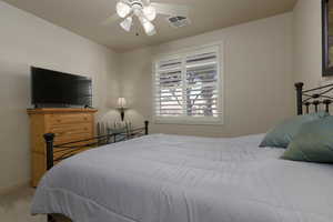 Bedroom featuring ceiling fan and carpet floors