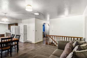 Living room featuring a textured ceiling, finished concrete floors, and arched walkways