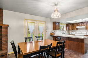Dining space featuring finished concrete floors, a chandelier, french doors, and a textured ceiling