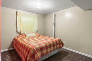 Bedroom featuring a textured ceiling and carpet flooring