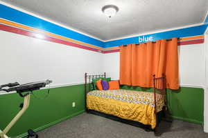 Bedroom featuring a textured ceiling and carpet flooring