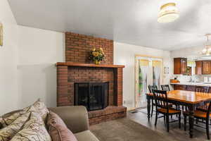 Dining room featuring a fireplace, a textured ceiling, and finished concrete flooring