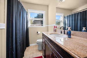 Full bath with vanity, a shower with curtain, and light tile patterned flooring